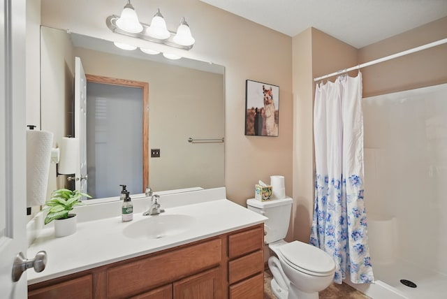 bathroom featuring vanity, toilet, and a stall shower