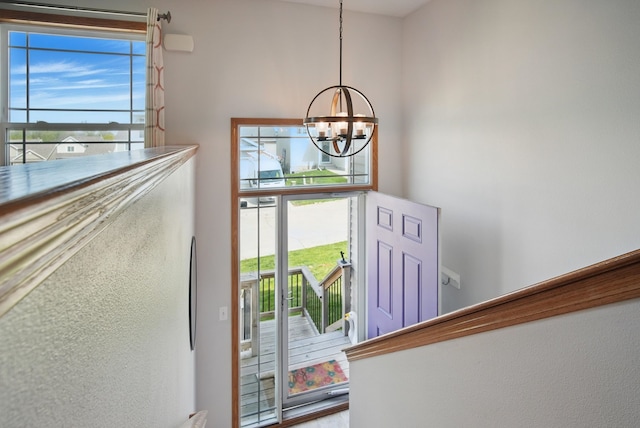 entrance foyer featuring an inviting chandelier and plenty of natural light