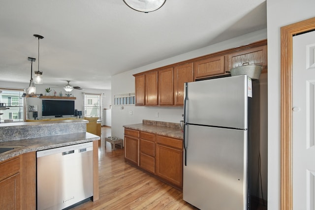 kitchen featuring ceiling fan, brown cabinetry, light wood finished floors, open floor plan, and stainless steel appliances