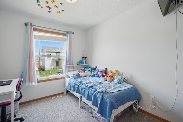 carpeted bedroom with baseboards, a textured ceiling, visible vents, and multiple windows