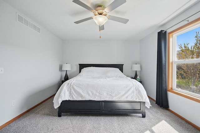 bedroom featuring baseboards, light carpet, a ceiling fan, and visible vents