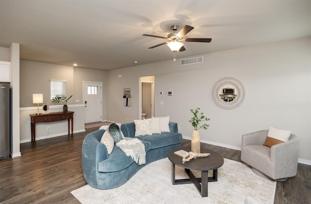 living area featuring visible vents, dark wood finished floors, ceiling fan, and baseboards