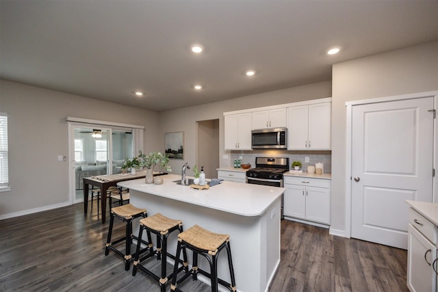 kitchen featuring a sink, white cabinets, stainless steel appliances, and dark wood finished floors