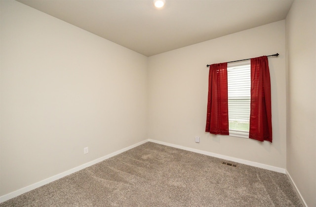 carpeted spare room featuring baseboards and visible vents