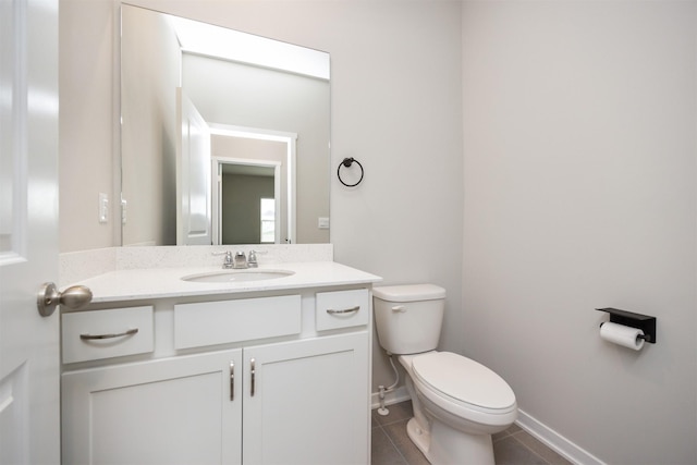 half bathroom with toilet, baseboards, tile patterned floors, and vanity