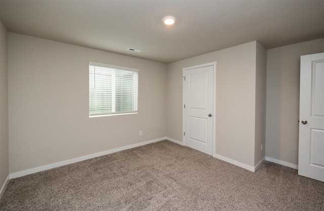 carpeted empty room with baseboards and visible vents