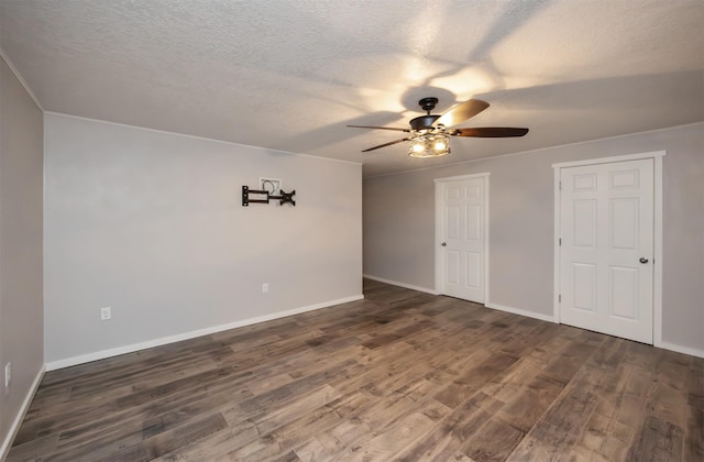 spare room with dark wood-style flooring, ceiling fan, and baseboards