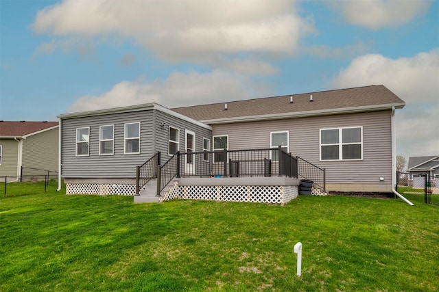 rear view of house featuring a yard, fence, and a wooden deck