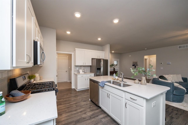 kitchen featuring light countertops, appliances with stainless steel finishes, a sink, and dark wood finished floors