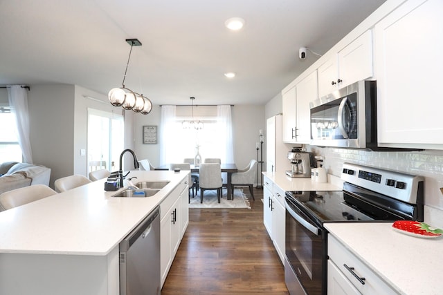 kitchen with appliances with stainless steel finishes, a sink, light countertops, white cabinetry, and dark wood-type flooring