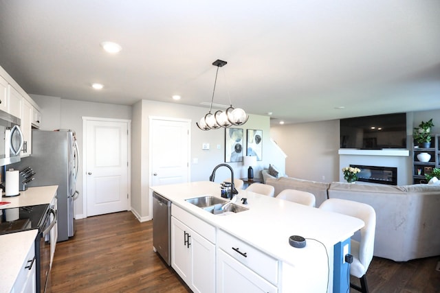 kitchen with a sink, light countertops, stainless steel appliances, and white cabinetry