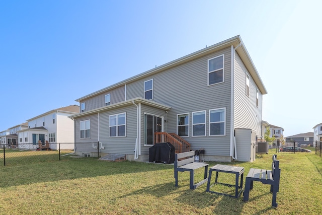 rear view of house with a yard and a fenced backyard