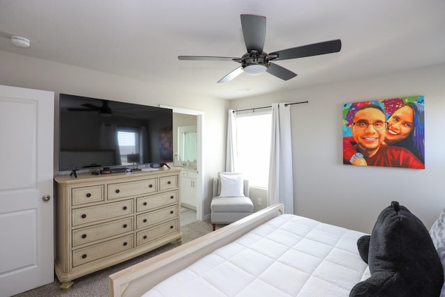 bedroom with carpet floors, ceiling fan, and ensuite bath