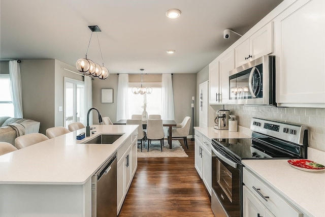 270 NW Charlestown Ln, Waukee, IA 50263 - kitchen with stainless steel appliances, light countertops, white cabinetry, and recessed lighting