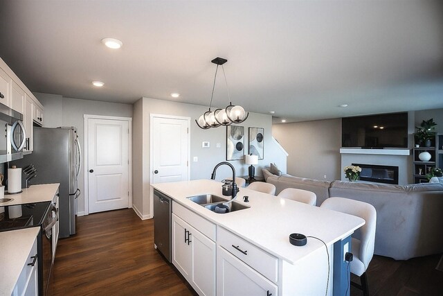 270 NW Charlestown Ln, Waukee, IA 50263 - kitchen featuring stainless steel appliances, a breakfast bar area, white cabinetry, light countertops, and recessed lighting