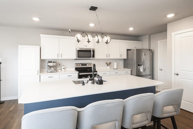 270 NW Charlestown Ln, Waukee, IA 50263 - kitchen featuring appliances with stainless steel finishes, a breakfast bar, white cabinets, dark wood-style flooring, and a center island with sink