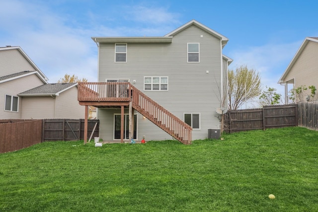 rear view of house with a lawn, a fenced backyard, stairway, and a deck