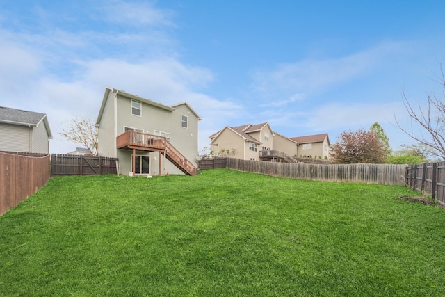 view of yard with a fenced backyard, a wooden deck, and stairway