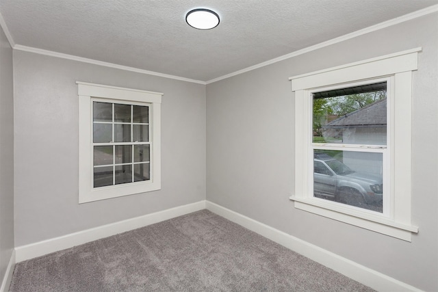 unfurnished room with a textured ceiling, ornamental molding, baseboards, and carpet