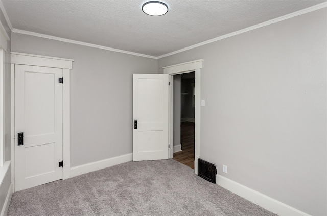 unfurnished bedroom featuring baseboards, ornamental molding, carpet, and a textured ceiling