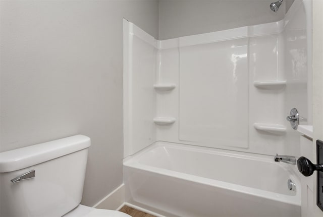 full bathroom featuring baseboards, tub / shower combination, and toilet