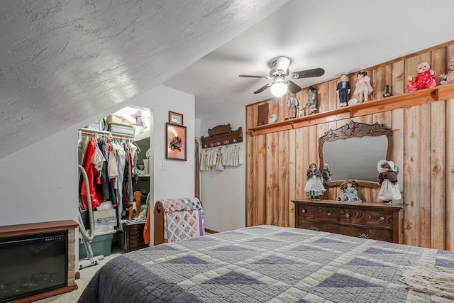bedroom featuring a ceiling fan, a closet, a spacious closet, carpet, and lofted ceiling