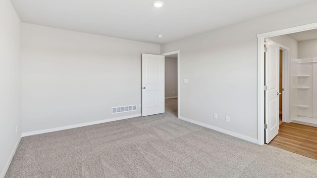 unfurnished bedroom with baseboards, carpet flooring, and visible vents