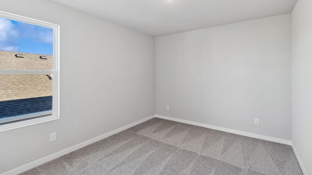 unfurnished room with baseboards and carpet flooring