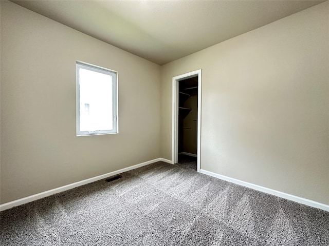 unfurnished room with baseboards, carpet flooring, and visible vents