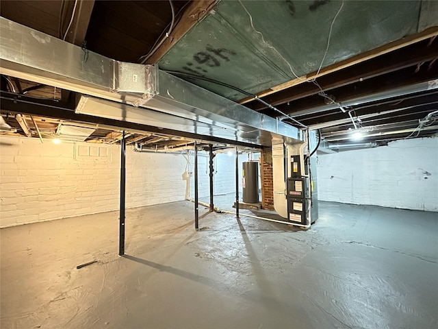 unfinished below grade area featuring heating unit and water heater