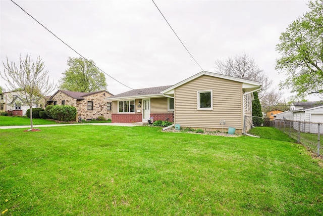 back of house with fence, a yard, and brick siding