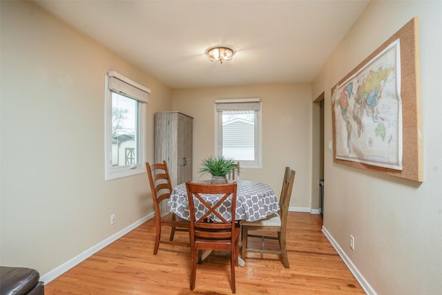dining room with baseboards and light wood finished floors