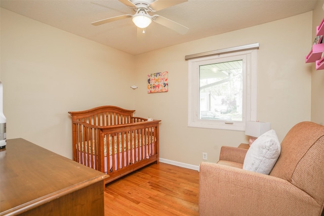bedroom featuring baseboards, ceiling fan, and light wood-style floors
