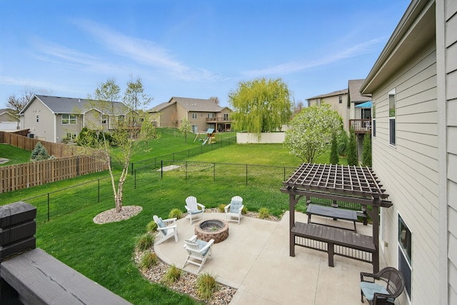 view of yard with a patio, a fenced backyard, a fire pit, and a residential view