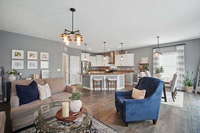 living room featuring recessed lighting, baseboards, a chandelier, and dark wood-style floors