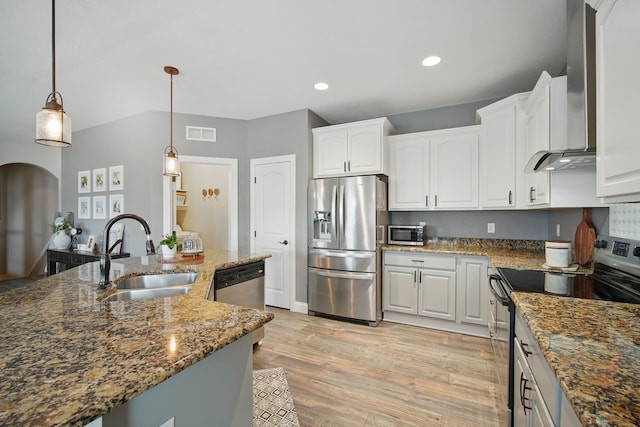 kitchen with a sink, dark stone counters, white cabinets, and stainless steel appliances