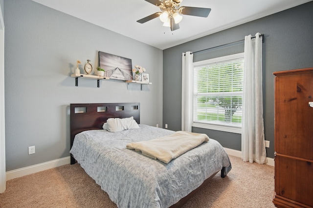 carpeted bedroom featuring baseboards and ceiling fan