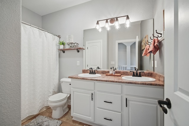 full bathroom with double vanity, toilet, a sink, and tile patterned flooring