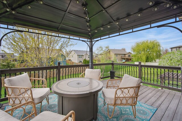 wooden deck featuring a residential view, a gazebo, and a yard