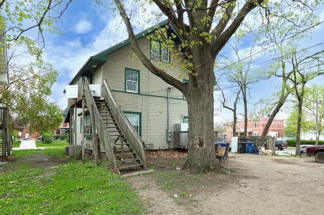 back of house featuring stairs and cooling unit