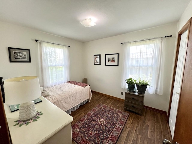 bedroom with dark wood-style flooring and baseboards