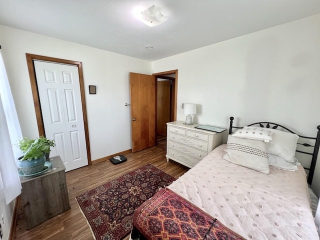 bedroom with baseboards and wood finished floors