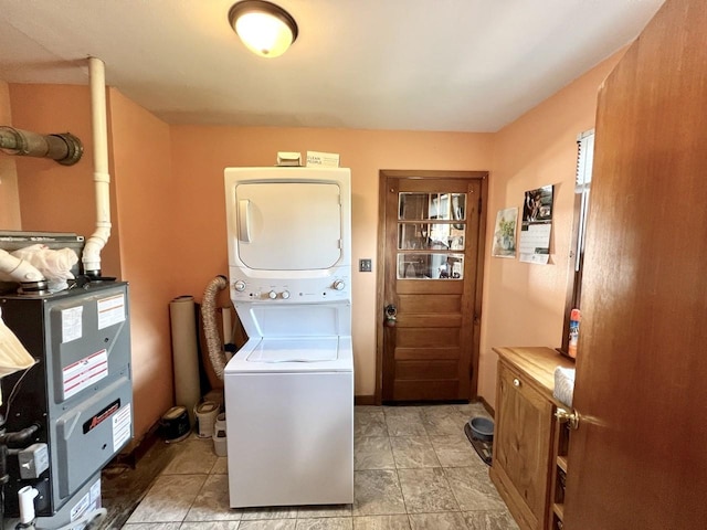 laundry room featuring cabinet space and stacked washer / dryer