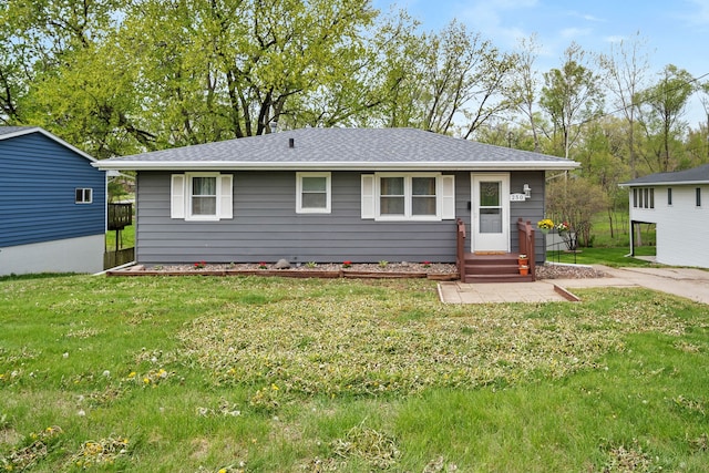 single story home with roof with shingles and a front lawn