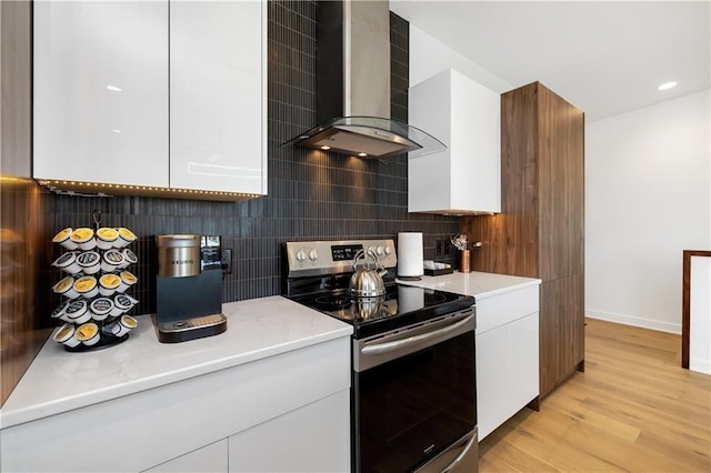 508 Indianola Rd Unit 1, Des Moines, IA 50315 - kitchen with decorative backsplash, electric range, modern cabinets, wall chimney range hood, and light wood-type flooring