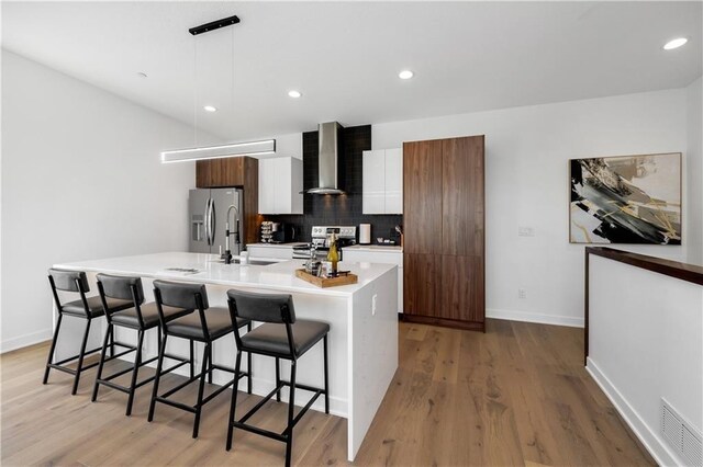 508 Indianola Rd Unit 1, Des Moines, IA 50315 - kitchen featuring a breakfast bar area, backsplash, wall chimney exhaust hood, and electric stove
