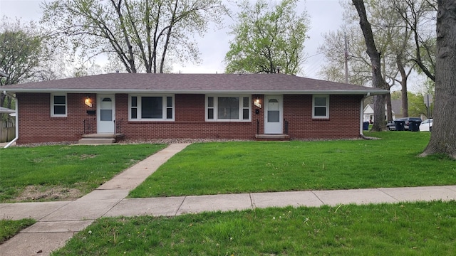 ranch-style house with entry steps, a front lawn, and brick siding