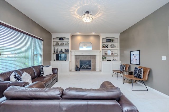4208 SW Camden Ridge Dr, Ankeny, IA 50023 - carpeted living room with built in shelves, a chandelier, a tile fireplace, and baseboards