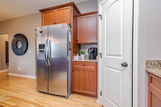 4208 SW Camden Ridge Dr, Ankeny, IA 50023 - kitchen with stainless steel refrigerator with ice dispenser, light wood-type flooring, brown cabinets, and baseboards