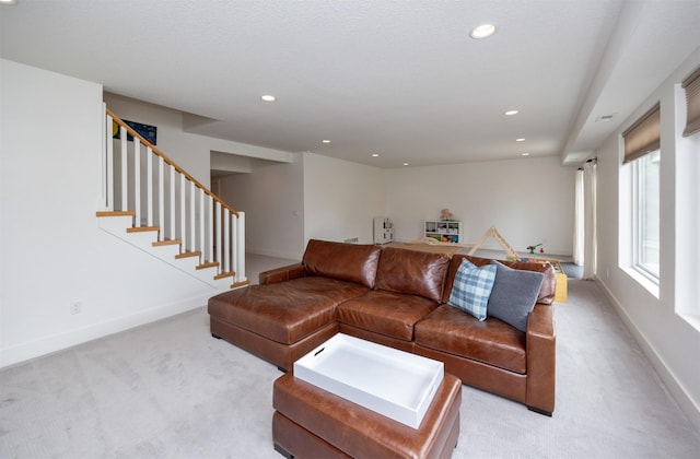 living room with light colored carpet, recessed lighting, and baseboards